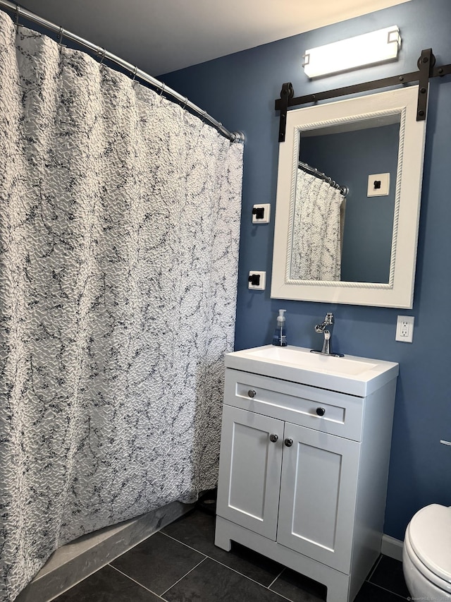 bathroom with tile patterned flooring, vanity, and toilet