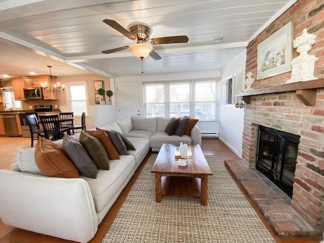 tiled living room with wood ceiling, ceiling fan, a fireplace, and sink