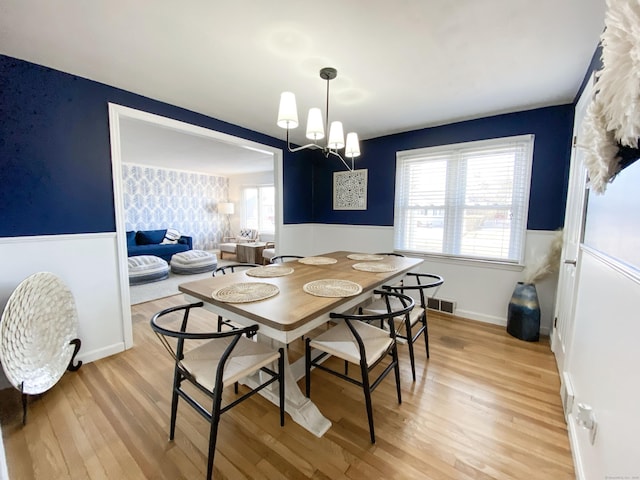 dining space with a chandelier and light wood-type flooring