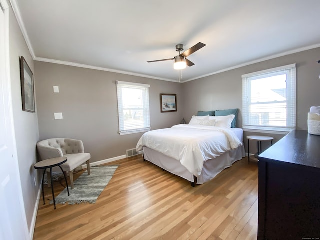 bedroom featuring ornamental molding, ceiling fan, and light wood-type flooring