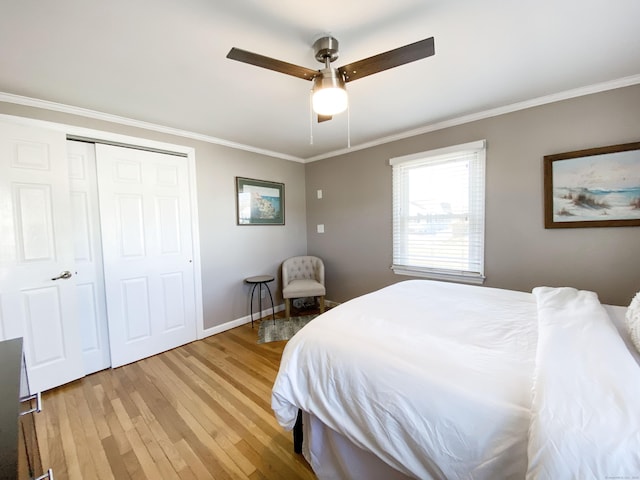 bedroom with crown molding, hardwood / wood-style flooring, a closet, and ceiling fan