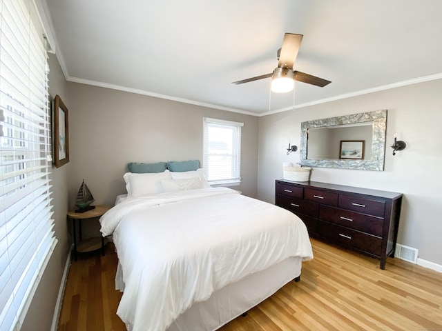 bedroom with crown molding, ceiling fan, and light hardwood / wood-style flooring