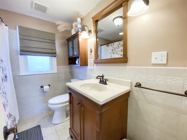 bathroom featuring tile walls, vanity, tile patterned floors, and toilet