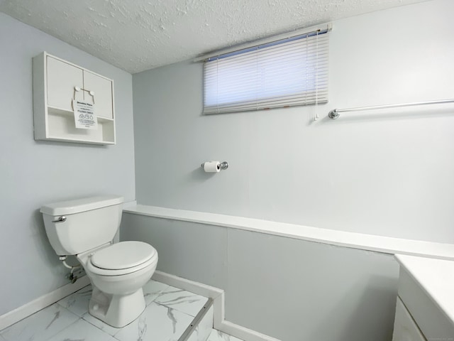 bathroom featuring vanity, toilet, and a textured ceiling