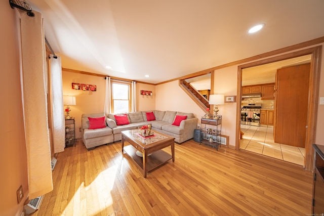 living room featuring ornamental molding and light wood-type flooring