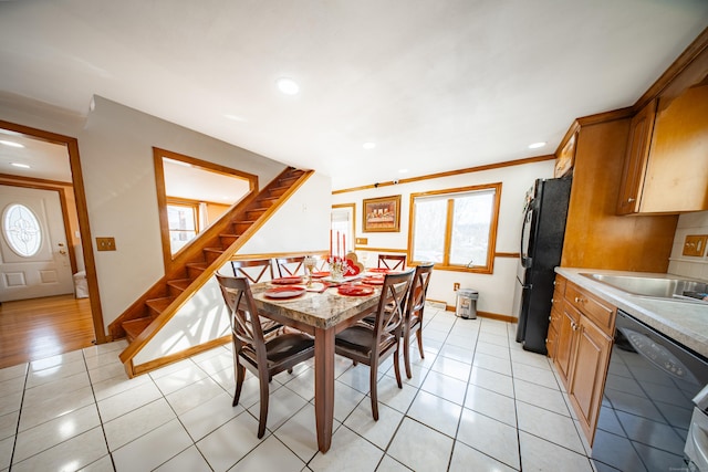 tiled dining area featuring sink, plenty of natural light, and ornamental molding