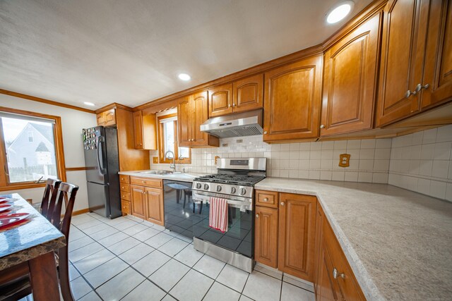 kitchen featuring sink, tasteful backsplash, crown molding, light tile patterned floors, and black appliances