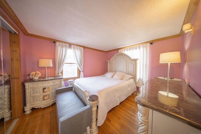 bedroom featuring crown molding, a closet, light hardwood / wood-style floors, and a textured ceiling