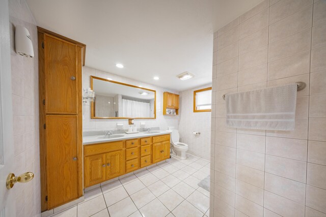 bathroom featuring tile walls, vanity, tile patterned flooring, and toilet