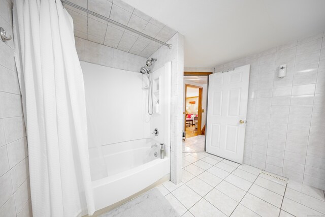 bathroom featuring tile patterned flooring, tile walls, and shower / tub combo with curtain