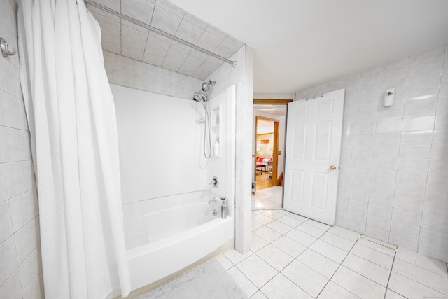 bathroom with tile patterned floors, tile walls, and shower / bath combination with curtain