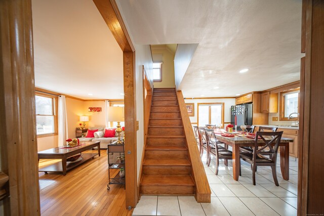 staircase featuring ornamental molding and wood-type flooring