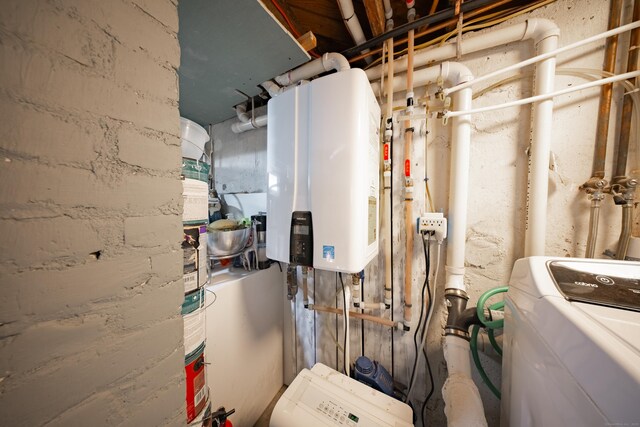 utility room featuring water heater and washer / dryer