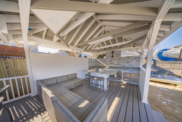 wooden deck featuring a bar and outdoor lounge area