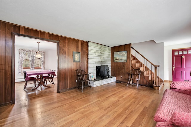 living room with wood-type flooring, a fireplace, and wood walls