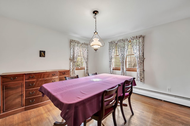 dining area with a baseboard radiator and light wood-type flooring