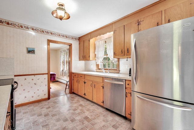 kitchen featuring sink, stainless steel appliances, and a baseboard heating unit