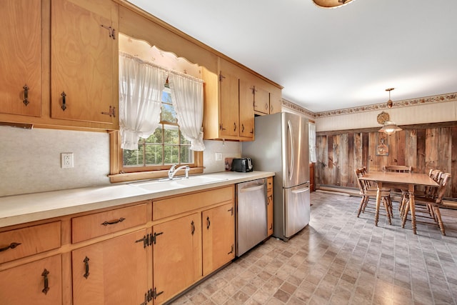 kitchen with appliances with stainless steel finishes, decorative light fixtures, and sink