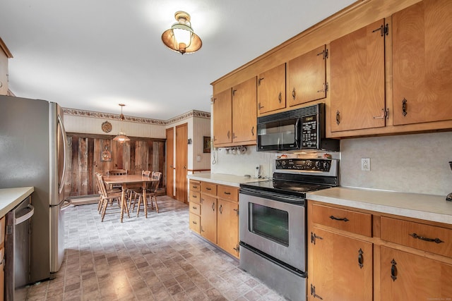 kitchen featuring stainless steel appliances, tasteful backsplash, and hanging light fixtures