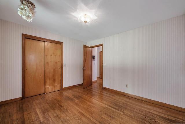 unfurnished bedroom with wood-type flooring and a closet