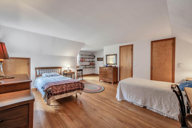 bedroom with vaulted ceiling and light hardwood / wood-style flooring