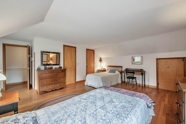 bedroom with wood-type flooring and lofted ceiling