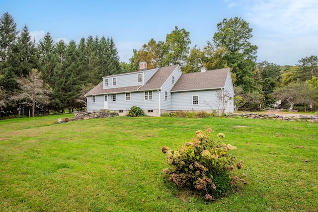 rear view of property featuring a lawn