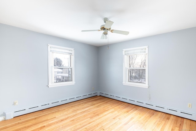 unfurnished room with a baseboard radiator, a healthy amount of sunlight, ceiling fan, and light wood-type flooring