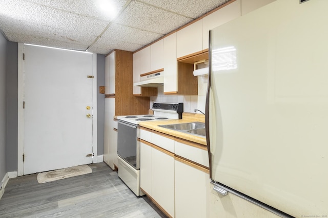 kitchen with sink, white appliances, a paneled ceiling, white cabinetry, and light hardwood / wood-style floors