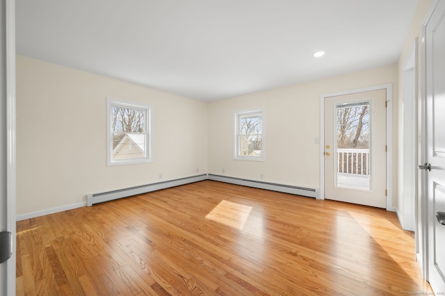 unfurnished room with light hardwood / wood-style floors and baseboard heating