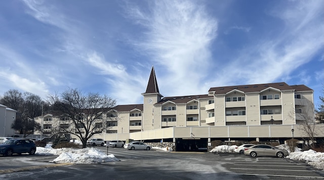 view of building exterior featuring uncovered parking and a residential view