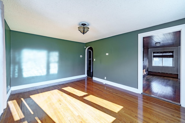 unfurnished room with hardwood / wood-style floors and a textured ceiling