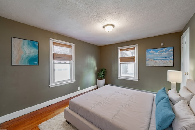 bedroom with light hardwood / wood-style flooring and a textured ceiling