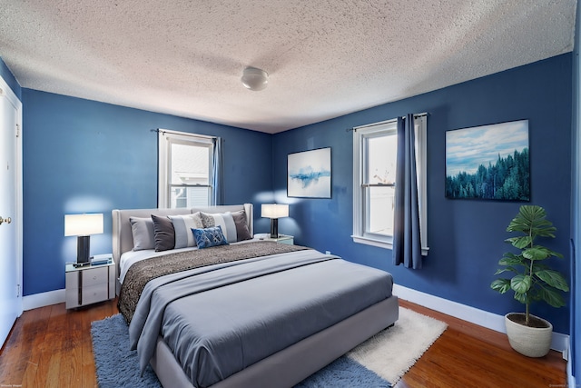 bedroom with dark wood-type flooring and a textured ceiling