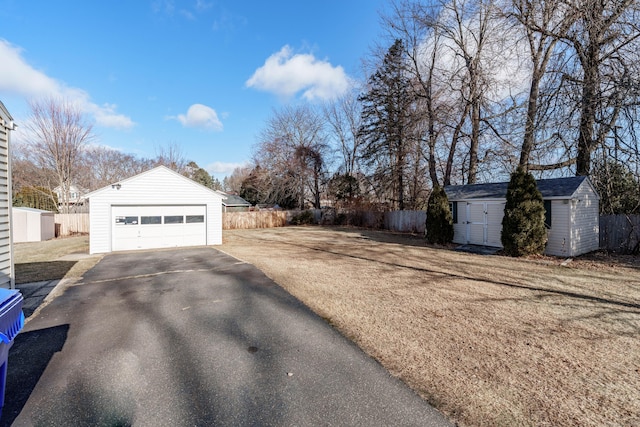 exterior space with a yard, a garage, and a storage unit