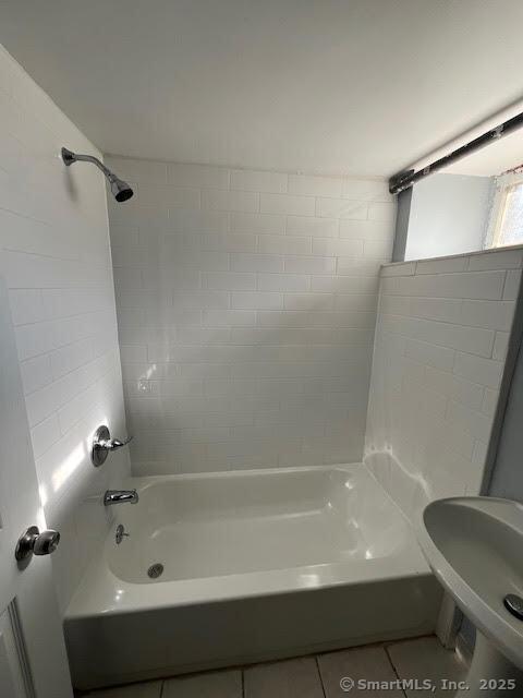 bathroom with tile patterned floors and tiled shower / bath