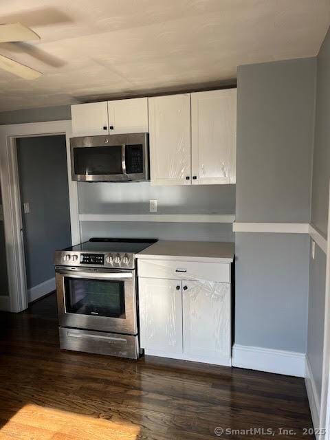 kitchen with white cabinetry, dark hardwood / wood-style floors, ceiling fan, and appliances with stainless steel finishes