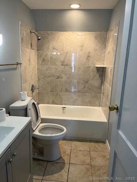 full bathroom with tiled shower / bath, vanity, tile patterned floors, and toilet