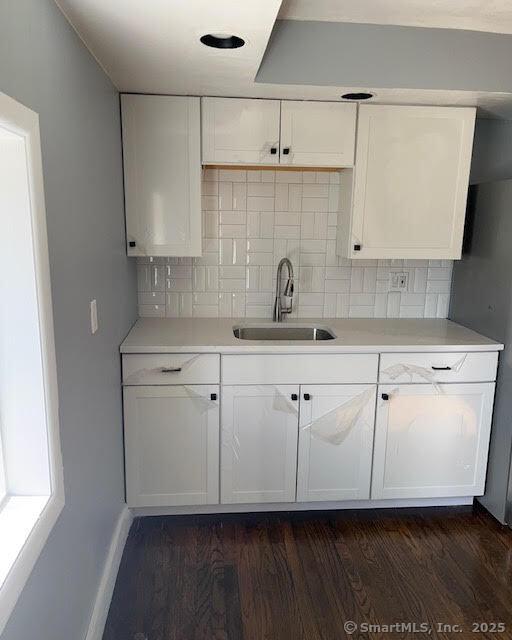 kitchen featuring white cabinetry, dark hardwood / wood-style floors, and sink