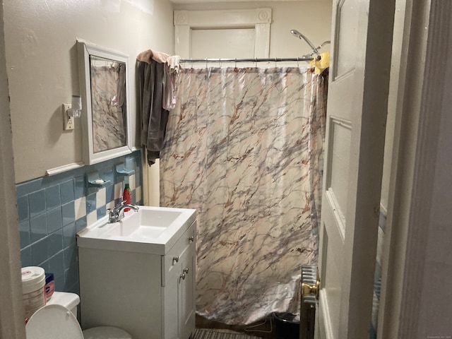 bathroom featuring toilet, tile walls, and vanity