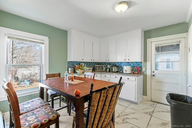 kitchen featuring backsplash and white cabinets