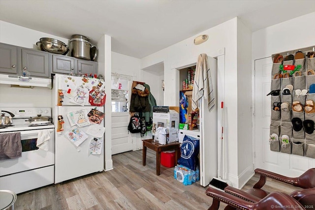 kitchen featuring white appliances, light hardwood / wood-style floors, and gray cabinetry