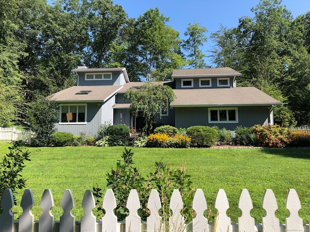 view of front of home with fence and a front lawn