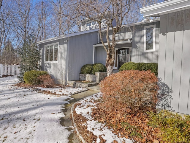 view of snow covered exterior with fence