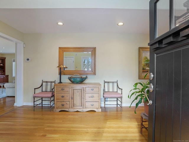 living area with light wood-type flooring, baseboards, and recessed lighting