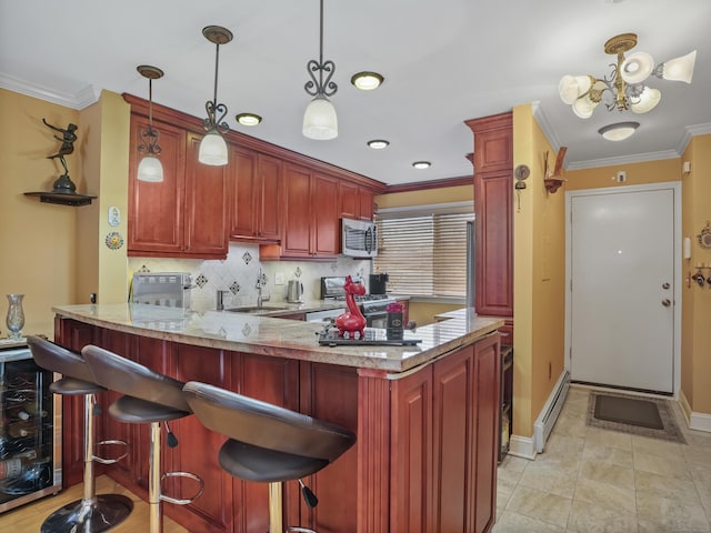 kitchen with a sink, stainless steel microwave, a baseboard heating unit, range with gas cooktop, and crown molding