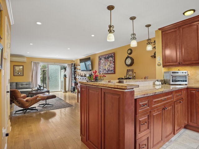 kitchen featuring a peninsula, a toaster, hanging light fixtures, crown molding, and open floor plan