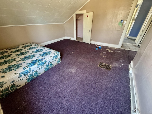 unfurnished bedroom featuring lofted ceiling and carpet floors