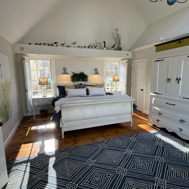 44 Brook St, Groton, CT 06340 - bedroom with visible vents, baseboards, high vaulted ceiling, and wood finished floors