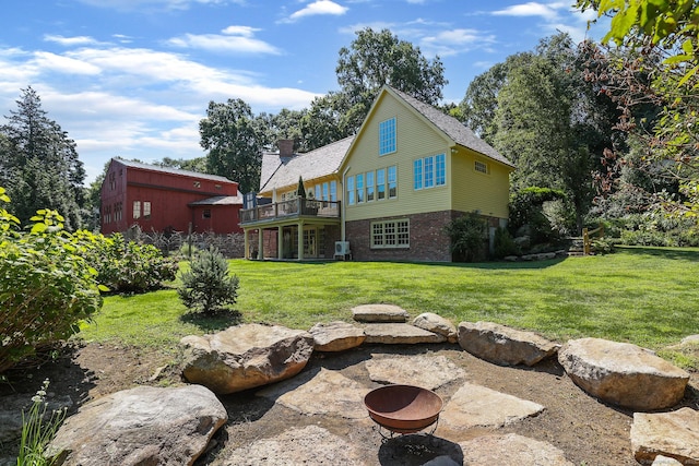 44 Brook St, Groton, CT 06340 - back of property with an outdoor fire pit, a yard, a wooden deck, brick siding, and a chimney
